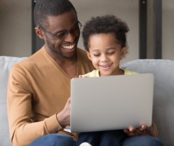 A parent and child looking at a laptop 