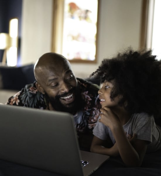 A parent and child looking at a laptop