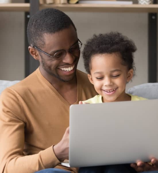 A parent and child looking at a laptop