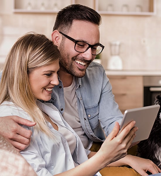 Happy couple smiling at a mobile device